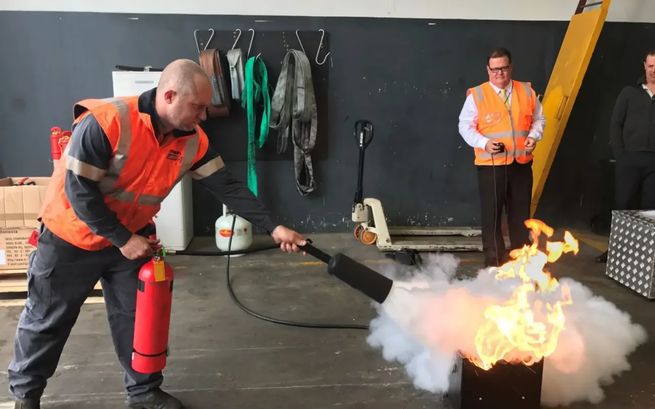 Deelnemers oefenen met een brandblusser