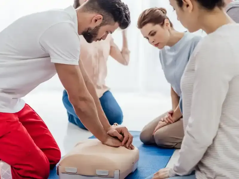Instructeur oefent reanimatie met een groep deelnemers